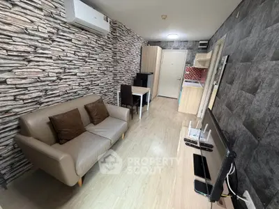 Modern living room with stylish stone accent wall and compact kitchen area.