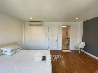 Spacious bedroom with wooden flooring and modern amenities