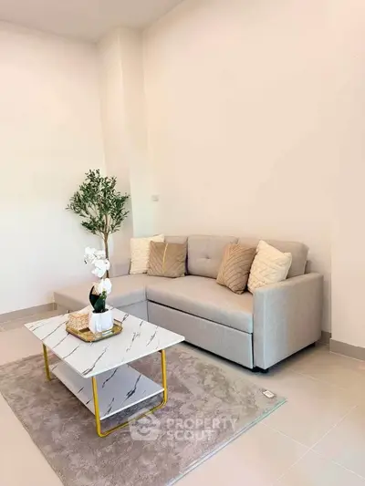Modern living room with stylish gray sofa and marble coffee table in a cozy setting.