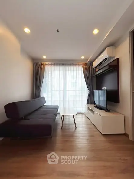 Modern living room with sleek furniture and large window for natural light.