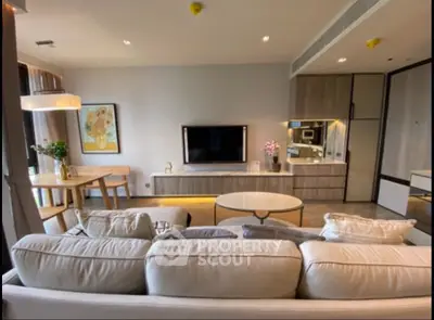 Modern living room with elegant decor and open layout, featuring a cozy sofa and stylish dining area.