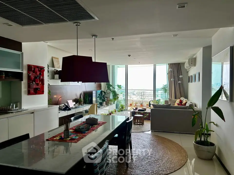Spacious modern living room with open kitchen and stunning city view, perfect for urban living.
