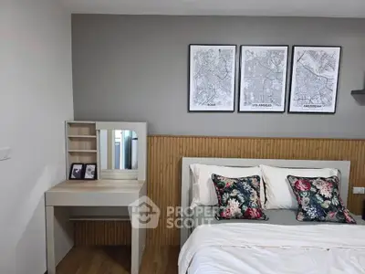 Chic bedroom with stylish decor and cozy bedding, featuring a modern vanity and framed city maps.