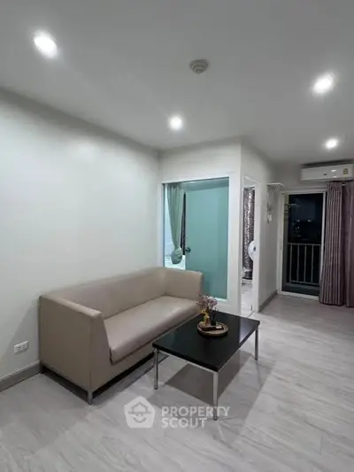 Modern living room with sleek sofa and balcony view in stylish apartment.