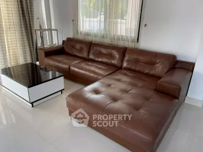 Spacious living room with elegant brown leather sectional sofa and modern coffee table.
