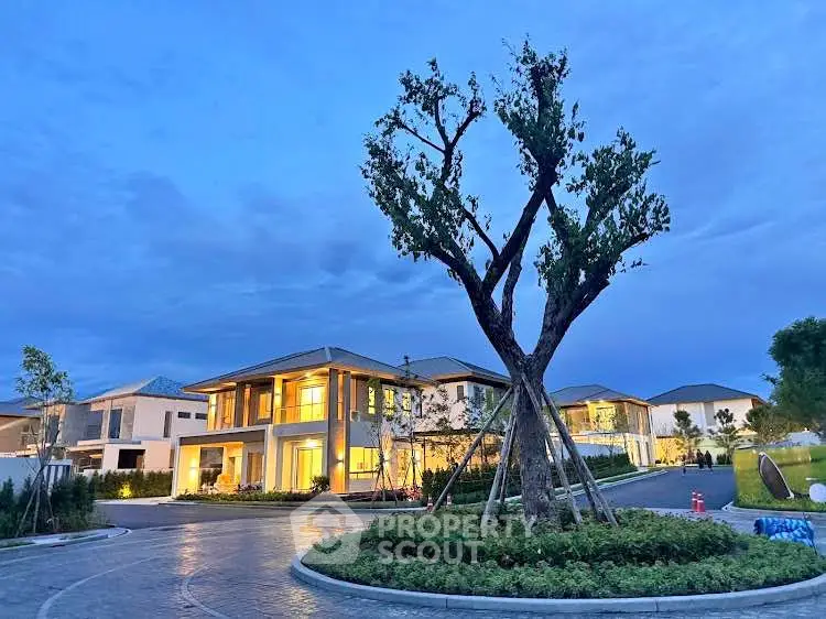 Stunning modern house with elegant exterior lighting and landscaped garden at dusk.