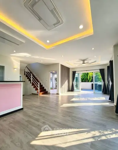 Spacious modern living room with large windows and stylish ceiling lights