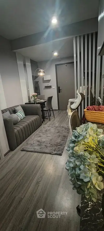 Modern living room with sleek gray sofa and stylish decor in a contemporary apartment.