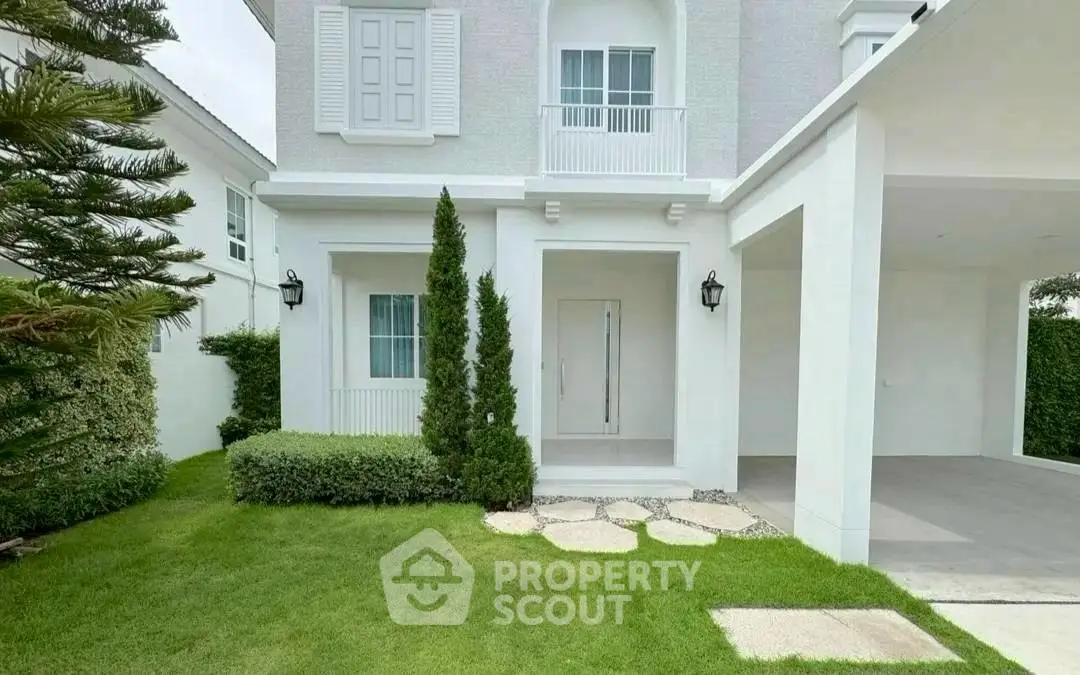Elegant white house exterior with lush green lawn and modern design.
