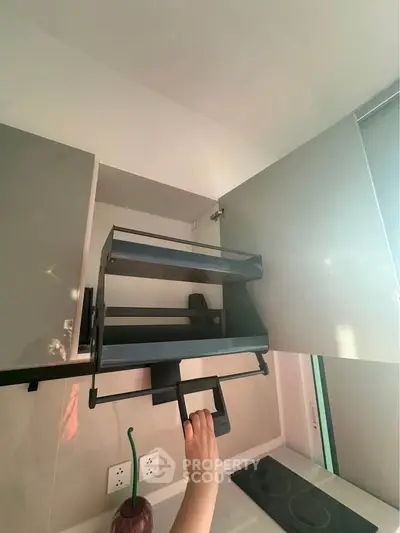 Modern kitchen with innovative pull-down cabinet storage solution.