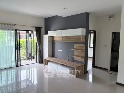 Modern living room with sleek furniture and large windows offering garden views.