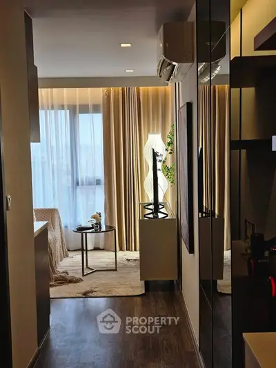 Modern living room with elegant decor and floor-to-ceiling windows offering natural light.