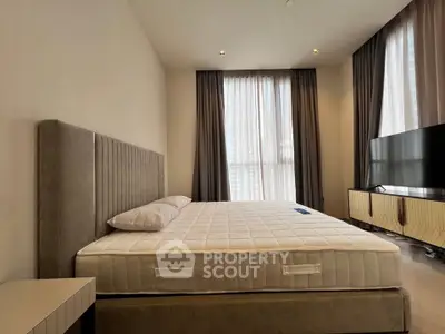 Spacious modern bedroom with elegant decor and large windows for natural light.