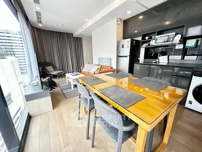 Modern open-plan living room with sleek kitchen and city view.