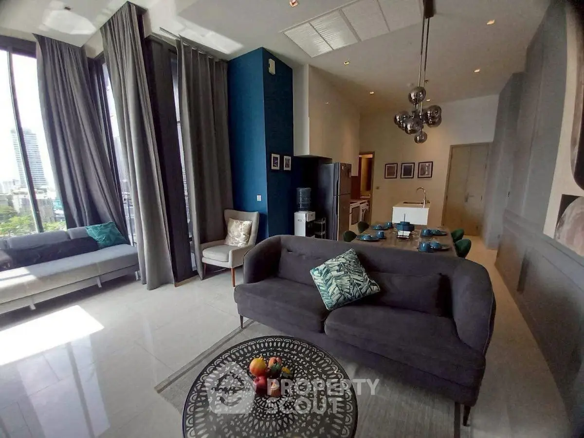 Modern living room with high ceilings, large windows, and stylish decor in a luxury apartment.