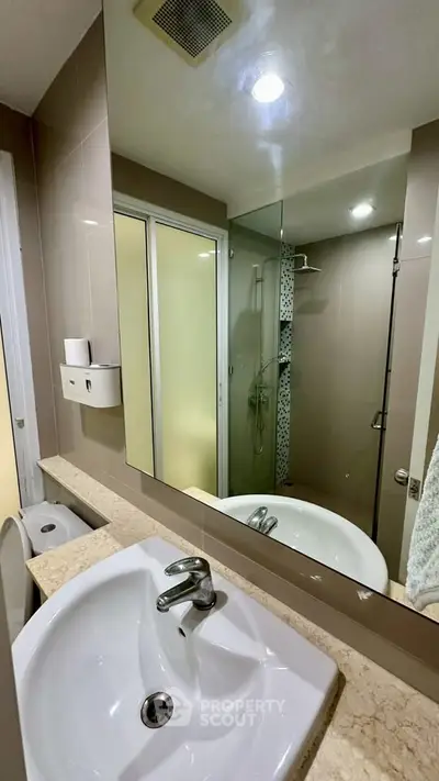 Modern bathroom with sleek fixtures and glass shower enclosure