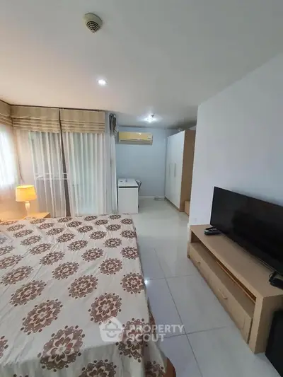 Spacious bedroom with modern decor and natural light in a stylish apartment.