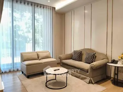 Elegant living room with modern furniture and large window offering natural light.