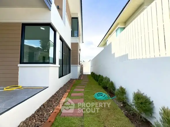 Modern house exterior with landscaped side yard and stepping stones