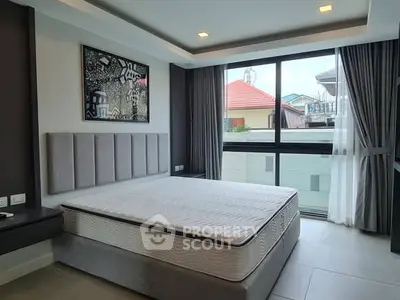 Modern bedroom with large window and stylish decor in a contemporary home.