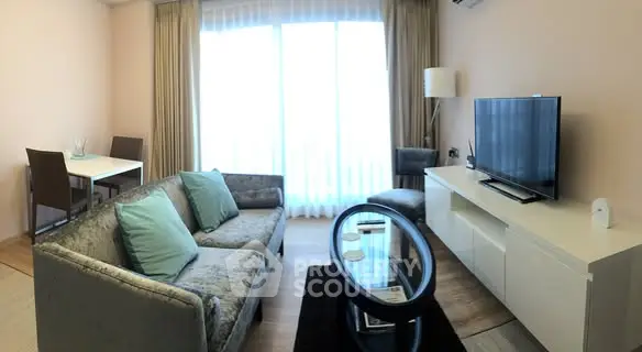 Modern living room with stylish furniture and large window, perfect for relaxation and entertainment.