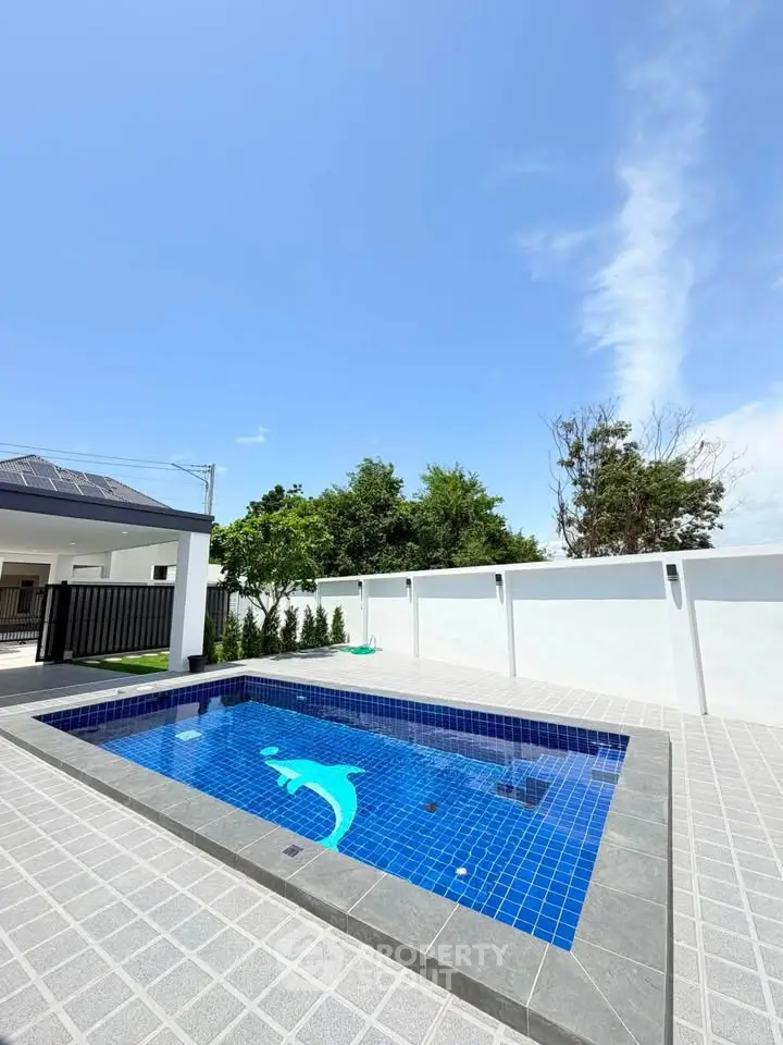 Stunning private pool with dolphin mosaic in modern backyard setting