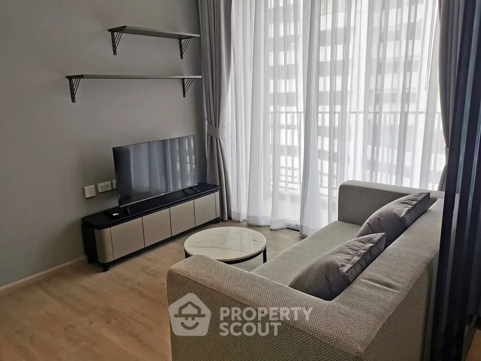 Modern living room with sleek furniture and large window for natural light.