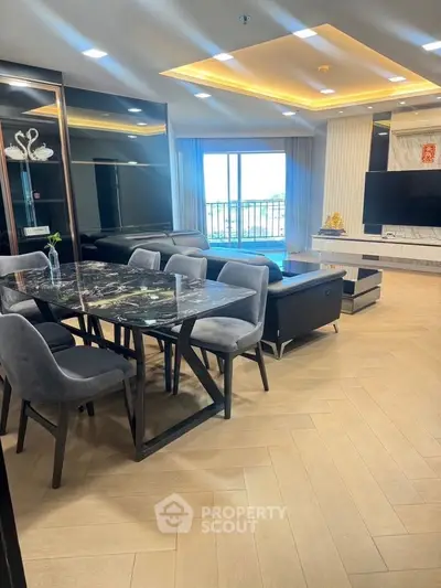 Luxurious modern living room with elegant dining area and large TV, featuring sleek furniture and stylish lighting.