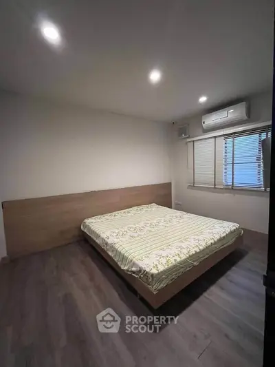 Spacious bedroom with modern design and large window for natural light.