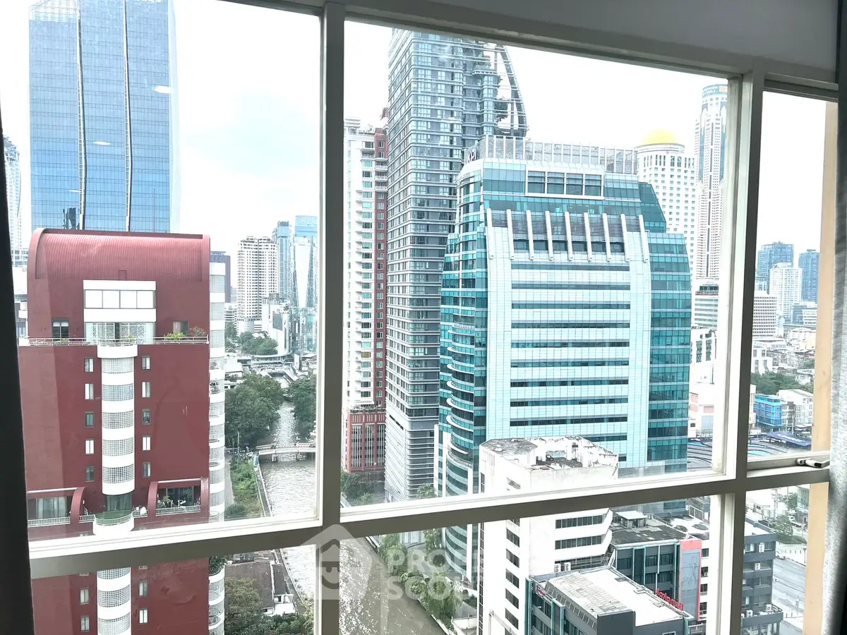 Stunning cityscape view from high-rise apartment window showcasing modern architecture.