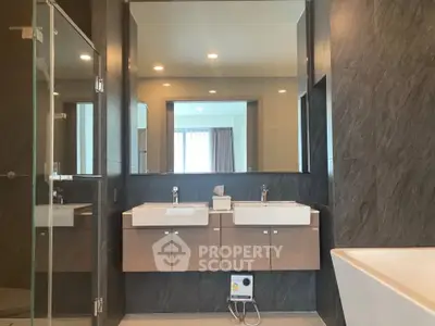 Modern bathroom with dual sinks and large mirror in luxury apartment