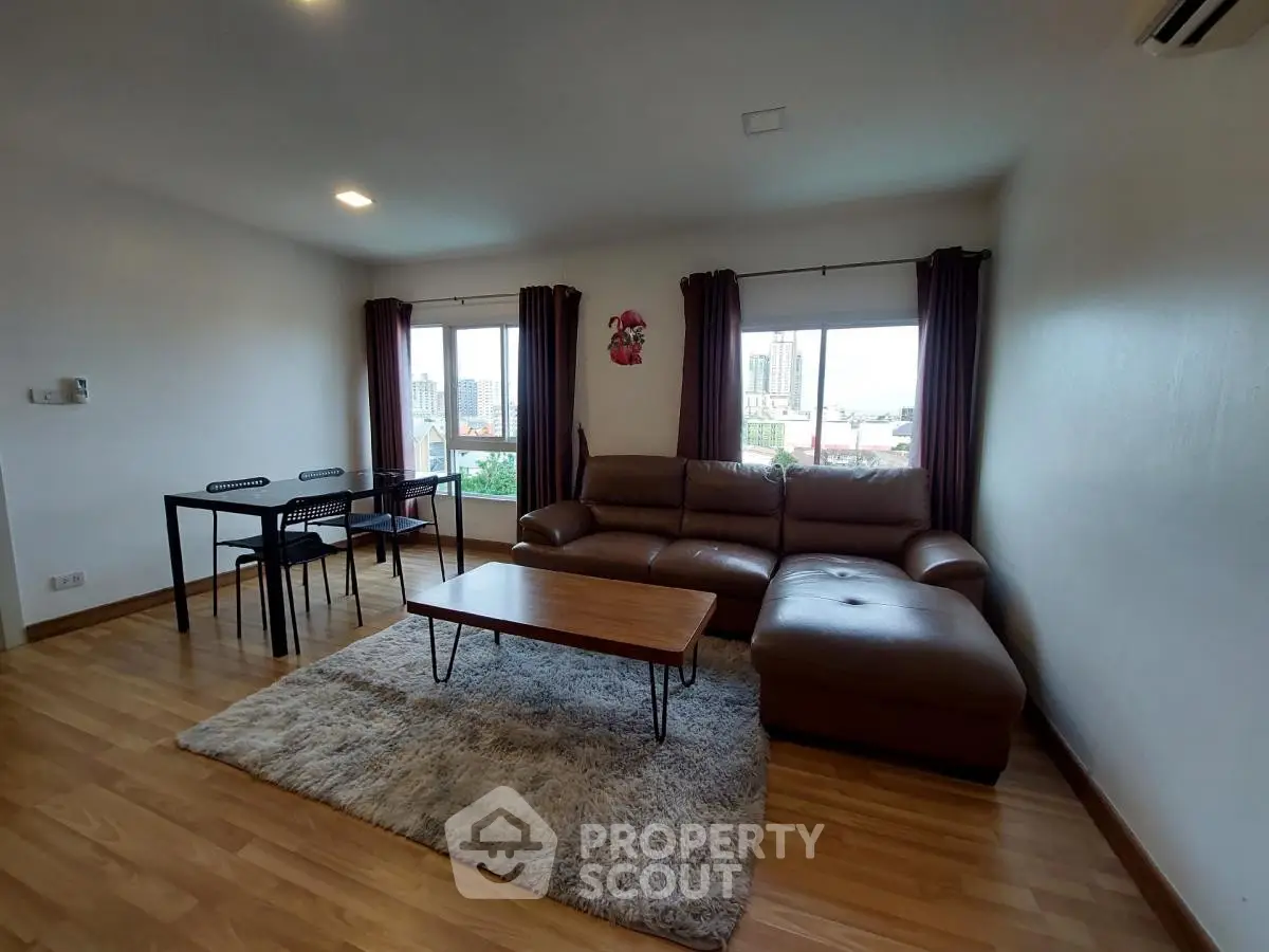Spacious living room with modern furniture and city view, perfect for relaxation and entertaining.