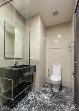 Modern bathroom with sleek fixtures and marble flooring in a contemporary apartment.