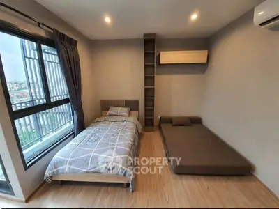 Modern bedroom with twin beds and large window offering city view, perfect for urban living.