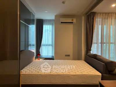 Modern bedroom with large window, air conditioning, and stylish decor in a high-rise apartment.