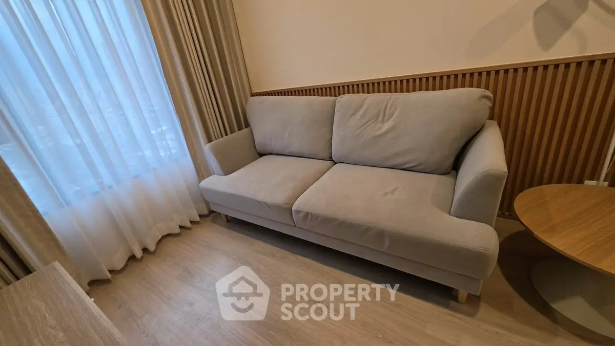 Cozy living room with a plush sofa and elegant wooden accents, perfect for relaxation.
