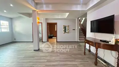 Spacious modern living room with sleek flooring and wall-mounted TV