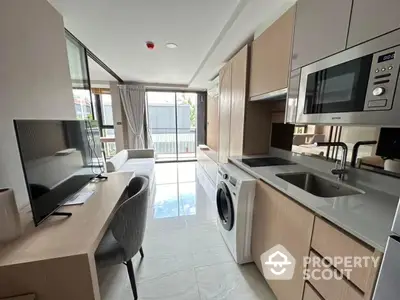 Modern apartment interior with sleek kitchen and living area, featuring built-in appliances and stylish decor.