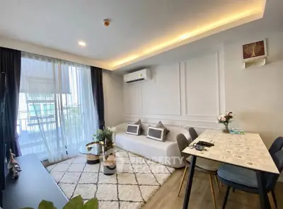 Modern living room with stylish decor, large window, and cozy seating area in a contemporary apartment.