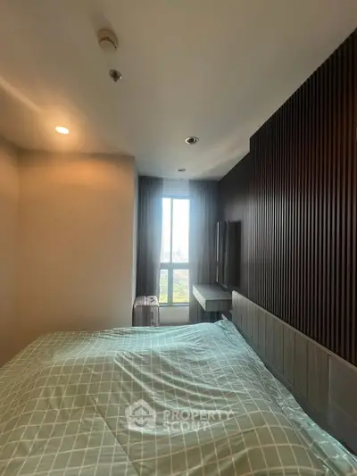 Cozy bedroom with modern design and large window offering natural light