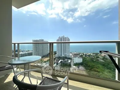 Stunning high-rise balcony with ocean view and modern outdoor seating.