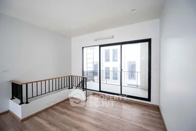 Bright and airy room with large windows and wooden flooring, perfect for modern living.
