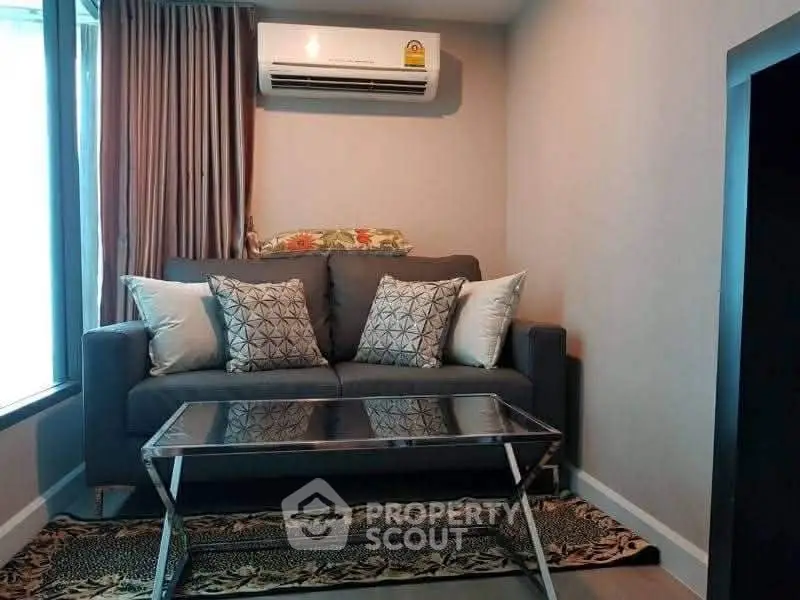 Cozy living room with modern sofa and air conditioning, perfect for relaxation.