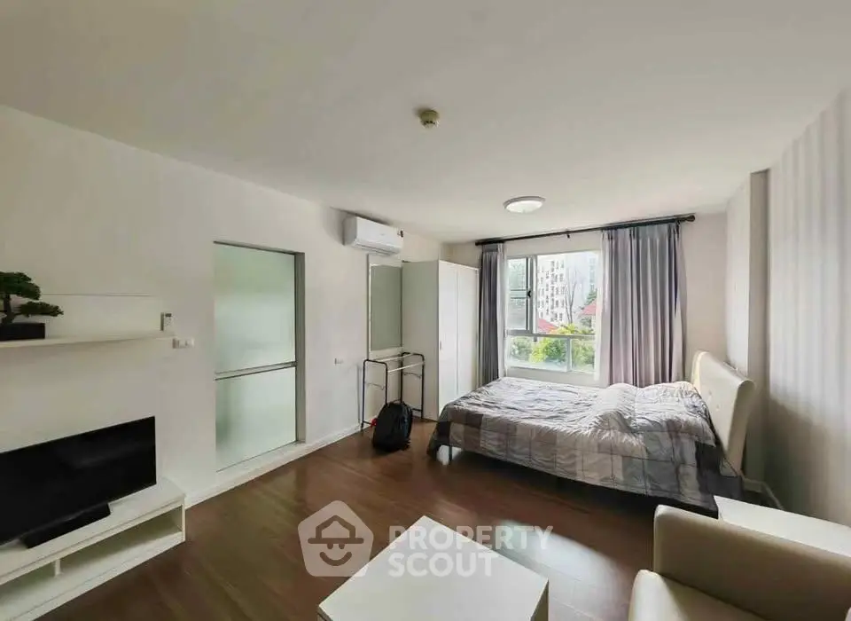 Modern bedroom with large window and stylish decor in urban apartment