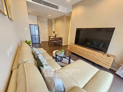 Modern living room with sleek furniture and large TV in a stylish apartment.