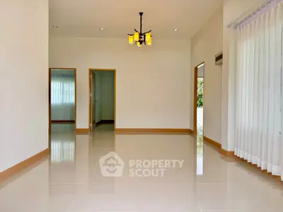 Spacious empty room with glossy tiled floor and modern lighting, perfect for customization.