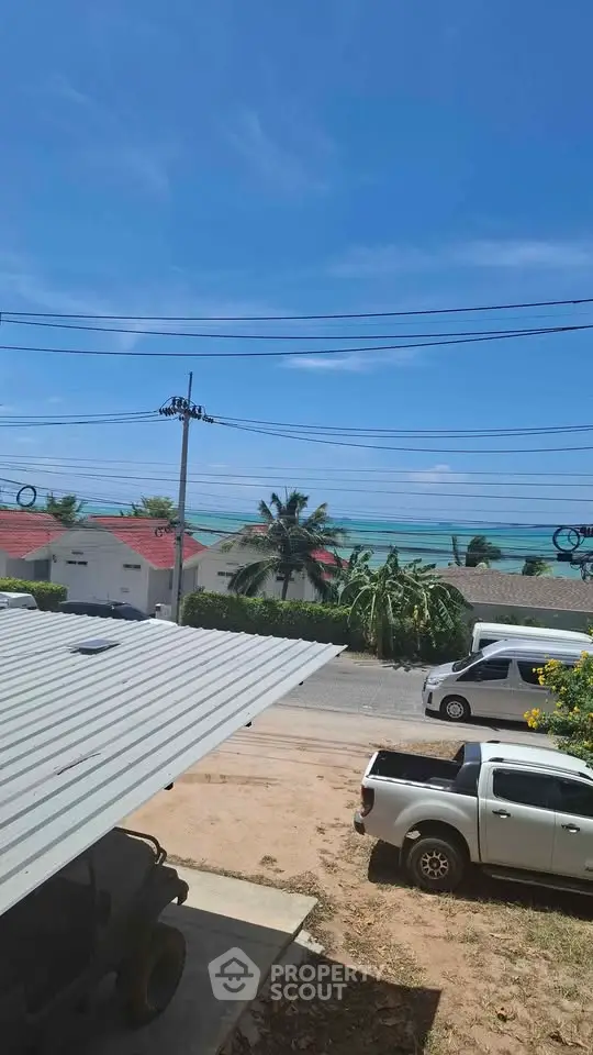 Stunning ocean view from a coastal property with clear blue skies and lush greenery.