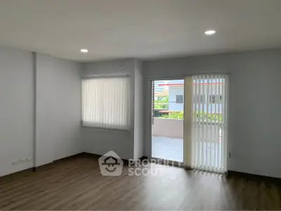 Spacious living room with large windows and balcony access in modern apartment.