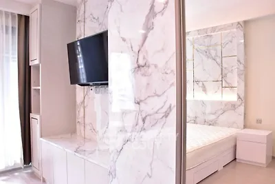 Luxurious bedroom with marble accents and modern TV setup