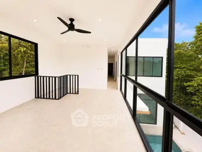 Spacious modern balcony with large windows and pool view, perfect for relaxation and enjoying nature.